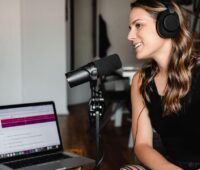 A woman laughs during a podcast