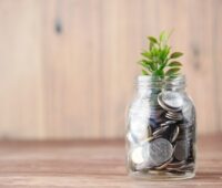 a glass jar filled with coins and a plant
