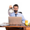 man in his office holding a clock