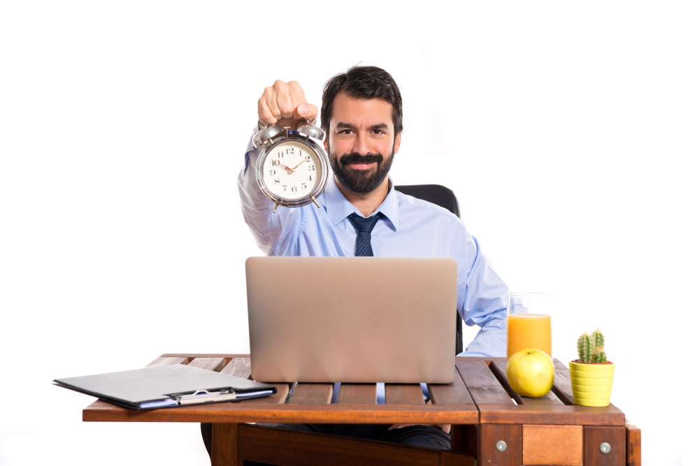 man in his office holding a clock
