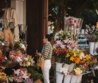 A lady is standing in-front of a shop