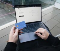 Holding a credit card while finalizing an online purchase, showcasing SumUp’s seamless integration for secure payments.