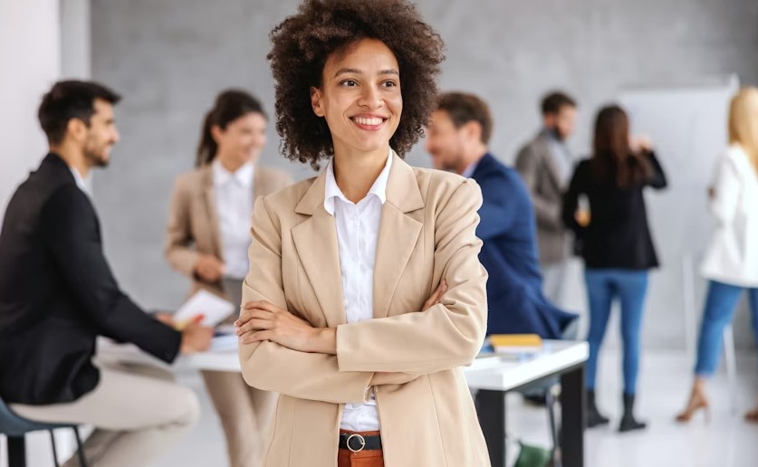 young smiling mixed race businesswoman standing in boardroom