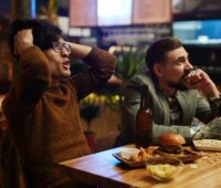 Man Holding his Head at a Bar