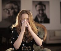 Sick Woman Wiping Her Nose with Tissue