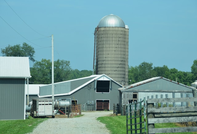Farm buildings with a silo stand under a blue sky