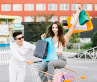 Man driving shopping cart with happy woman