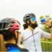 A girl stands with a man drinking water from a bottle