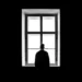 A person looks out the window in a dark room