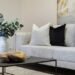 A living room with white furniture and black accents