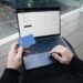 Holding a credit card while finalizing an online purchase, showcasing SumUp’s seamless integration for secure payments.