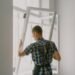 workman installing window in house during renovation process
